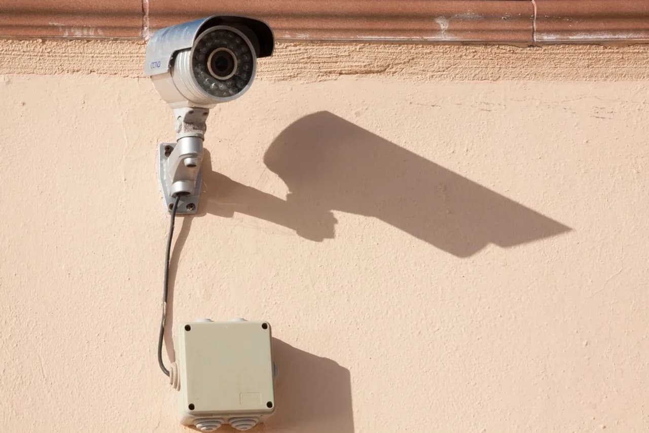 Caméra de surveillance fixée sur la façade d’un bâtiment ensoleillé