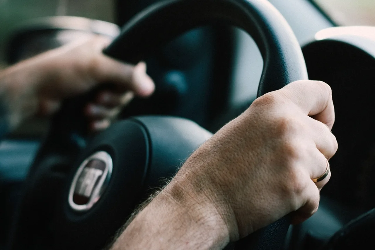 Mains d’un élève posées sur le volant pendant une leçon de conduite
