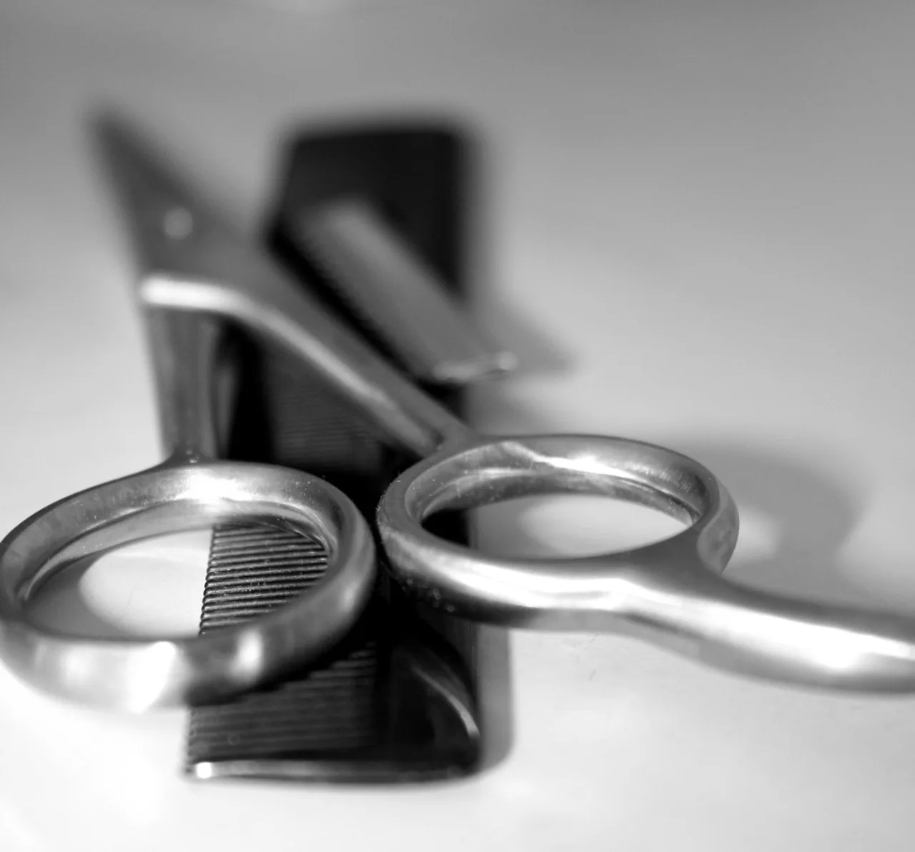 Ciseaux de coiffeur en gros plan, lames croisées en noir et blanc