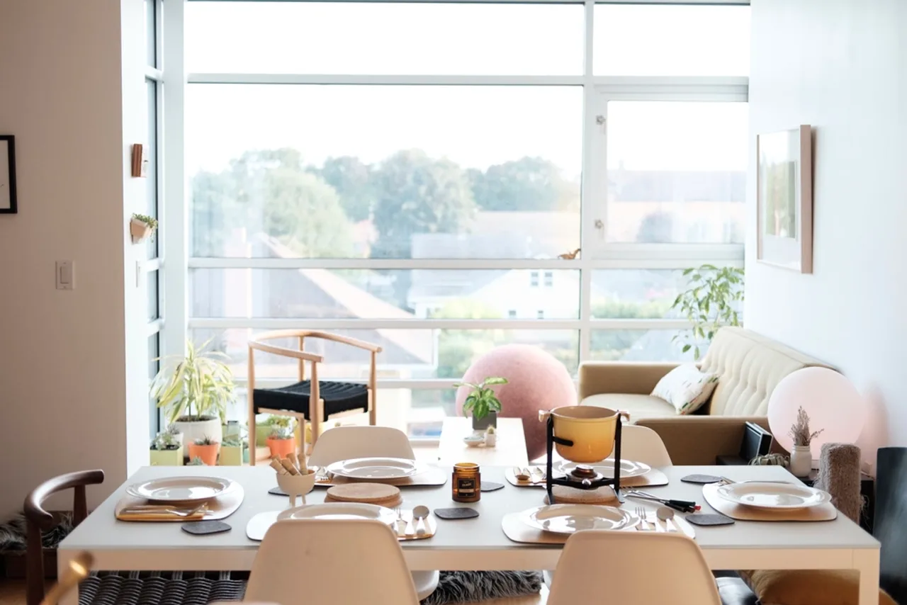 Table dressée près d’une grande baie vitrée dans une salle lumineuse