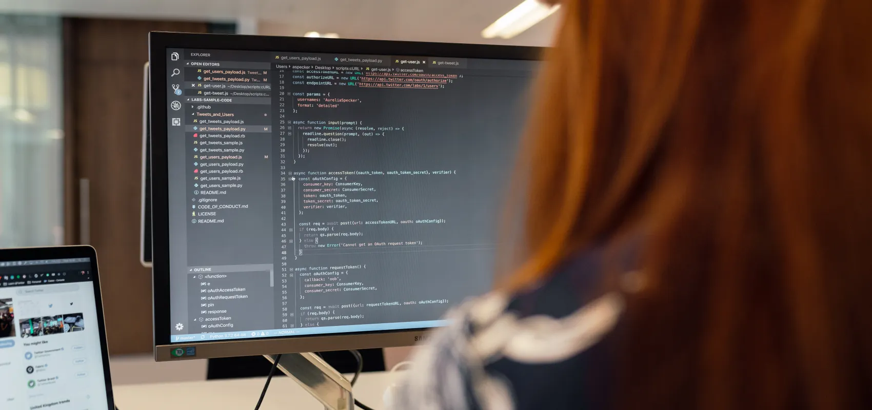 Développeuse écrivant le code d’une application SaaS sur un grand écran