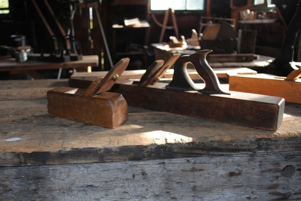 Rabots et outils de menuiserie alignés sur l’établi d’un atelier de bois